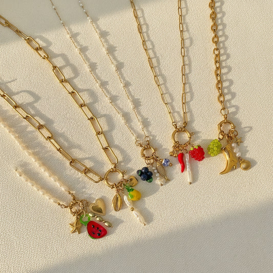 Collection of necklaces with various charms on a light background